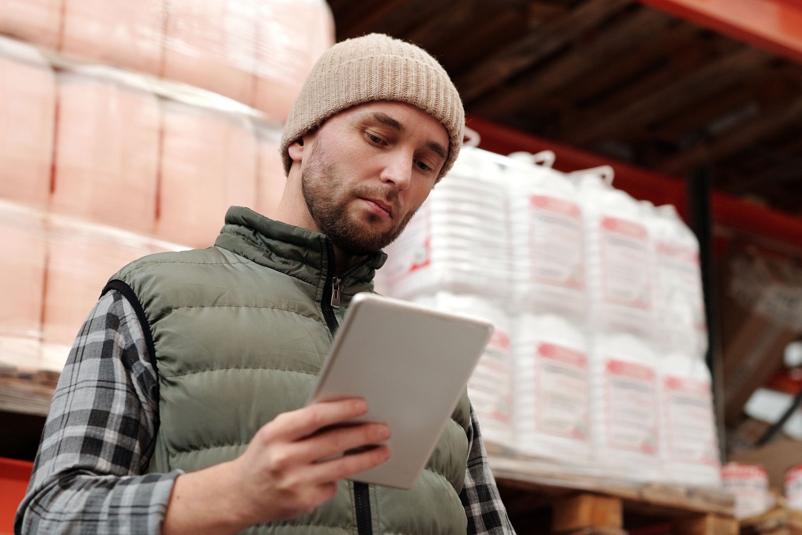 Warehouse worker checking stock on a tablet: the physical activity behind every purchase invoice